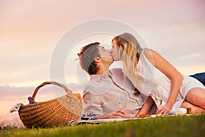 Attractive couple kissing on romantic picnic