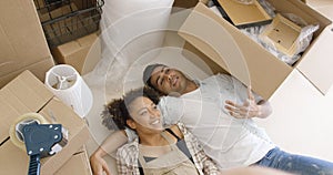 Attractive couple lying on the floor of their home