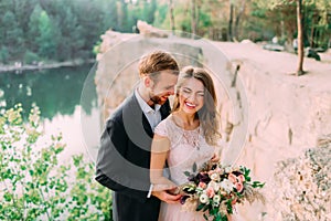 Attractive couple newlyweds bride and groom laugh and smile, happy and joyful moment. Wedding ceremony outdoors