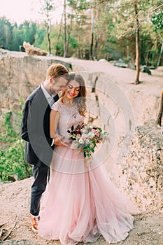 Attractive couple newlyweds bride and groom laugh and smile, happy and joyful moment. Wedding ceremony outdoors