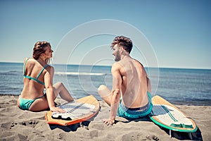 Attractive couple outdoors back view- surfers on the beach Water