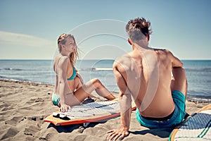 Attractive couple outdoors - surfers on the beach Water sports.