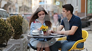 Attractive couple relaxing in sidewalk cafe