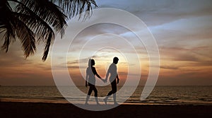 Attractive couple relaxing and walking on a tropical beach