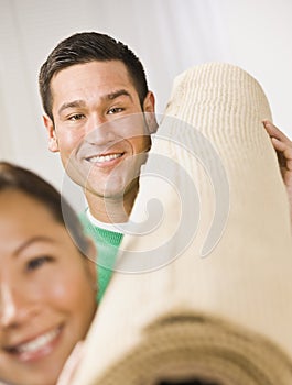 Attractive Couple with Roll of Carpet