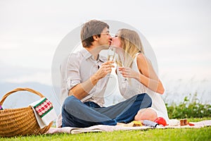 Attractive couple on romantic afternoon picnic kissing
