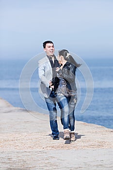 Attractive couple running along of pier