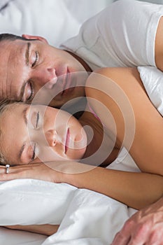 Attractive couple sleeping and spooning in bed