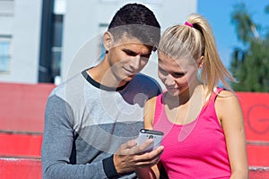 Attractive couple with smartphone outside