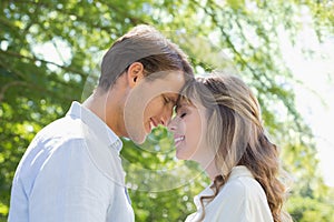 Attractive couple smiling at each other in the park