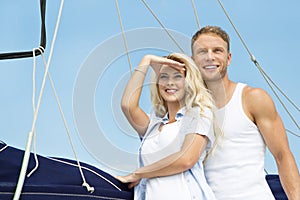 Attractive couple standing on sailing boat - sailing trip.