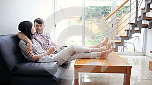 Attractive couple talking sitting on the couch in modern home