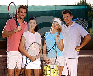 Attractive couples on tennis court smiling