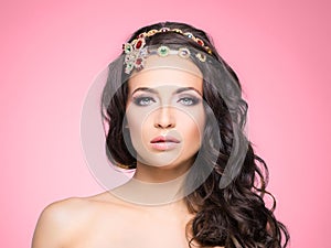 Attractive, curly brunette with flower alike golden headband wit