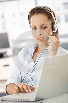 Attractive customer servicer using headphones