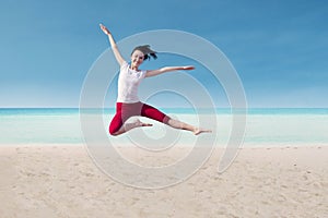 Attractive dancer jumping on beach