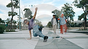 Attractive dancer perform break dance in front of friend cheering. Sprightly.