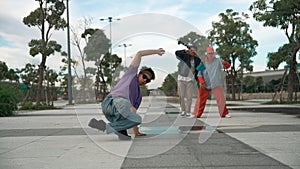 Attractive dancer perform break dance in front of friend cheering. Sprightly.