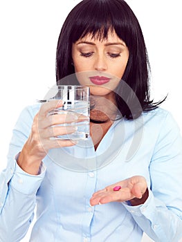 Attractive Dark Haired Young Woman Holding a Glass and Taking Medicine