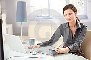 Attractive designer using tablet and laptop