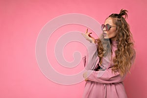 Attractive dissatisfied asking young blonde woman wearing everyday stylish clothes and modern sunglasses  on