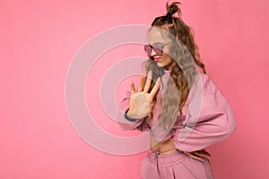 Attractive dissatisfied young blonde woman wearing everyday stylish clothes and modern sunglasses  on colorful