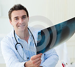 Attractive doctor examining an x-ray photo