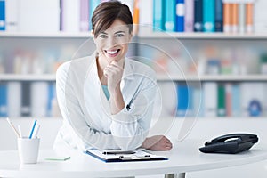 Attractive doctor posing at the clinic reception photo