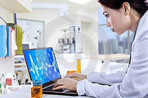 Attractive doctor working with laptop in lab