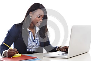 Attractive and efficient black ethnicity woman sitting at office computer laptop desk typing