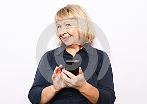 Attractive elderly woman with smartphone over white backgrou