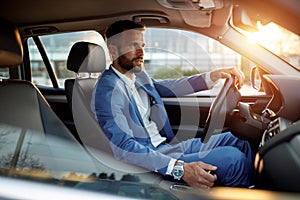 Attractive man in business suit driving car