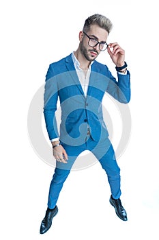 Attractive elegant man in suit with untied shirt arranging eyeglasses