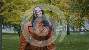 Attractive energetic happy young woman actively dancing incendiary moving outdoors in autumn park carefree hispanic girl