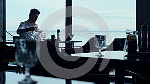 Attractive entrepreneur waiting business meeting in stylish restaurant sea view