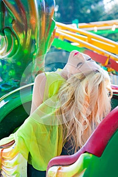 Attractive fashion beautiful blonde woman in elegant yellow dress in amusement park summer