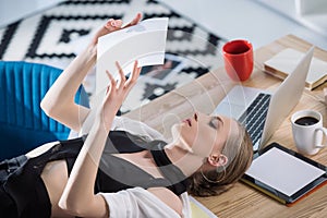 attractive fashion designer lying on desk and looking