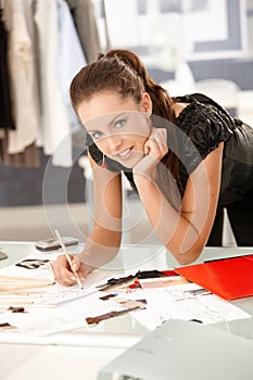 Attractive fashion designer working in office