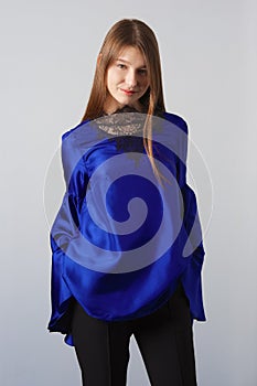 Attractive fashion model in blue silk blouse with butterfly sleeves