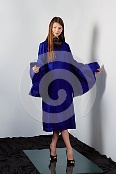 Attractive fashion model in blue silk dress with butterfly sleeves