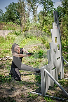 Attractive female army soldier have gun shooting training around cover