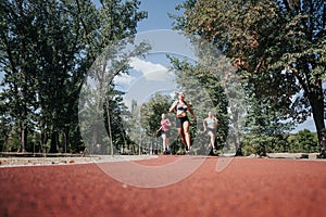 Attractive Female Athletes Having Fun Exercising Outdoors in a Sunny Day at the Park, Running on a Race Track.