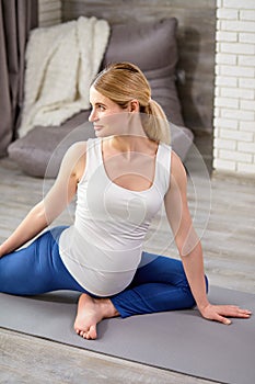 attractive female with big belly, happy pregnant lady in sportswear doing fitness yoga exercises