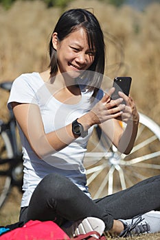 attractive female biker using phone outdoors