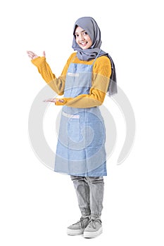 attractive female cafe worker with hijab presenting to copyspace