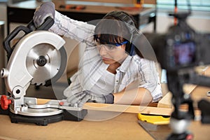 attractive female carpenter using power tools for work