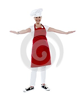 Attractive female chef in red apron and toque