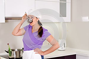 Attractive female chef sampling the recipe