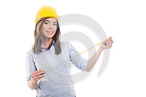 Attractive female constructor holding tape line wearing hardhat