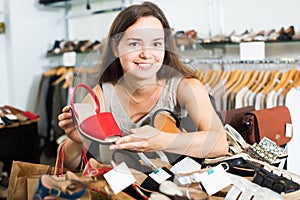 Attractive female customer selecting shoes in footgear center